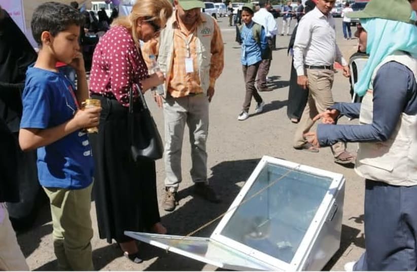 A UN Population Fund respresentative inspects the Solar Oven (photo credit: NASNA FOUNDATION)