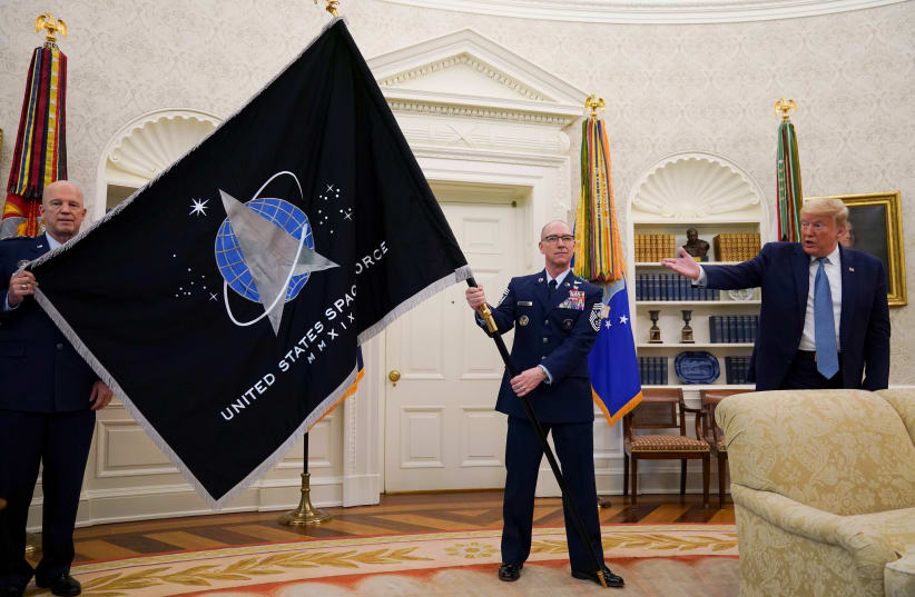 US President Donald Trump gestures towards the US Space Force flag during a presentation of the flag in the Oval Office of the White House in Washington, US, May 15, 2020.  (photo credit: KEVIN LAMARQUE/REUTERS)