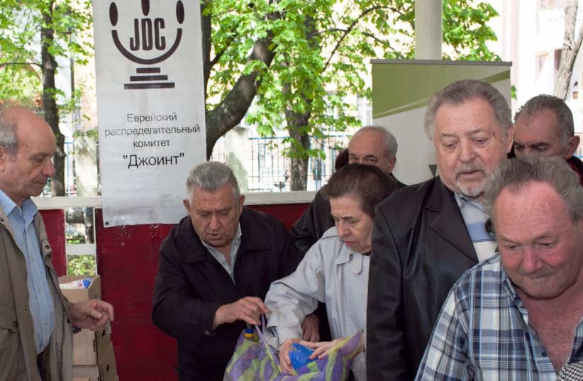 Elderly Ukrainians receive food packages at the Hesed social welfare center in Donetsk run by JDC (photo credit: COURTESY OF JDC/JTA)