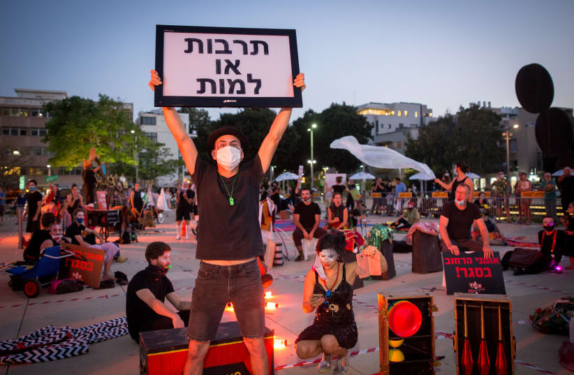 Street performers take part in a protest calling for financial support from the Israeli government at Habima Square in Tel Aviv, following the lockdown Israel has been in order to prvevent the spread of the Coronavirus, on May 20, 2020. (photo credit: MIRIAM ALSTER/FLASH90)