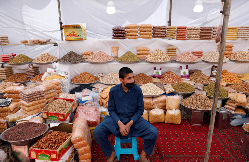 An Afghan boy waits for customers ahead of the Eid al-Fitr, marking the end of the fasting month of Ramadan amid the spread of the coronavirus disease (COVID-19), in Kabul, Afghanistan May 21, 2020 (photo credit: REUTERS/MOHAMMAD ISMAIL)