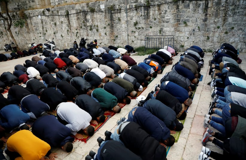 Palestinians perform Eid al-Fitr prayers marking the end of the holy fasting month of Ramadan, amid the coronavirus disease (COVID-19) restrictions, outside the compound housing al-Aqsa mosque in Jerusalem's Old City May 24, 2020. (photo credit: RONEN ZVULUN/REUTERS)