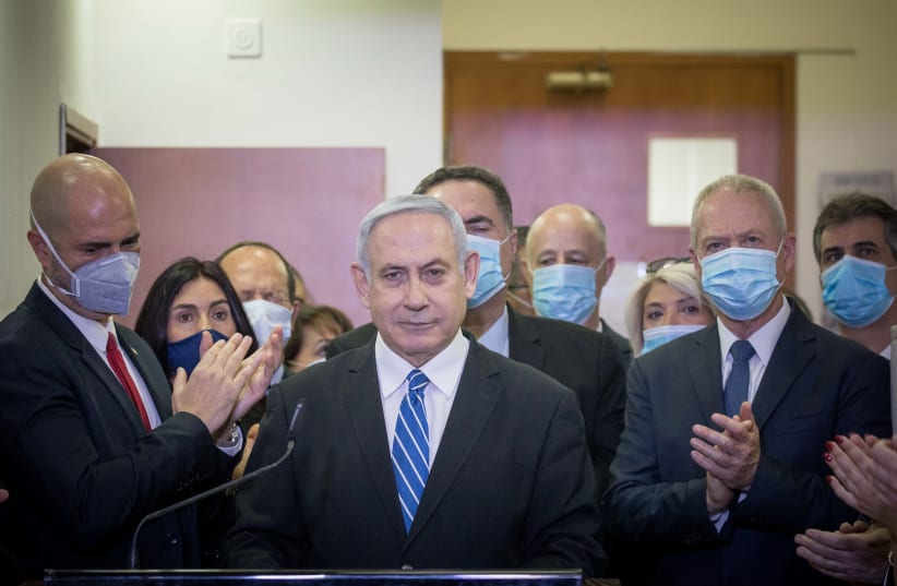Likud MKs applaud Prime Minister Benjamin Netanyahu ahead of his first trial hearing on Sunday (photo credit: YONATAN SINDEL/FLASH90)