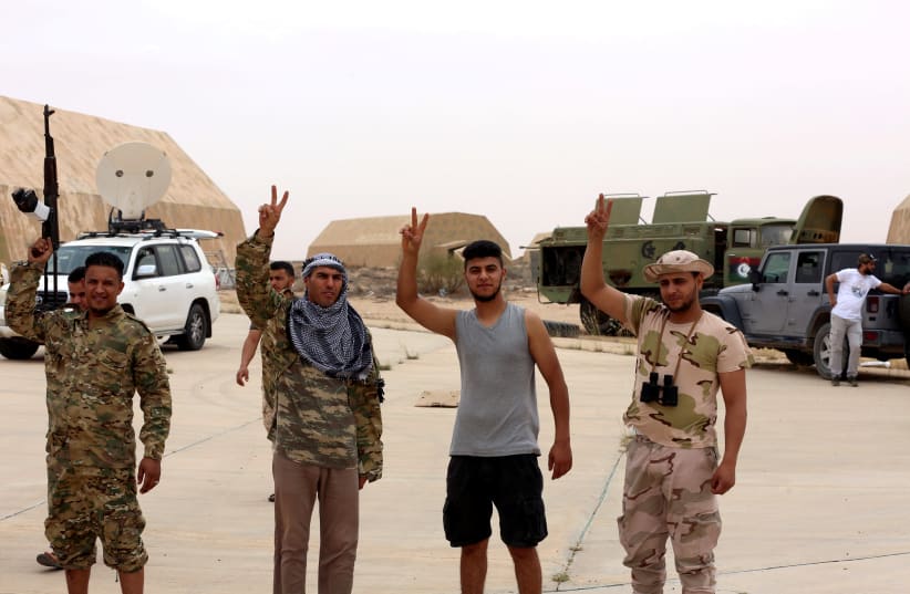 Members of Libya's internationally recognised government flash victory signs after taking control of Watiya airbase, southwest of Tripoli, Libya May 18, 2020. (photo credit: REUTERS/HAZEM AHMED)