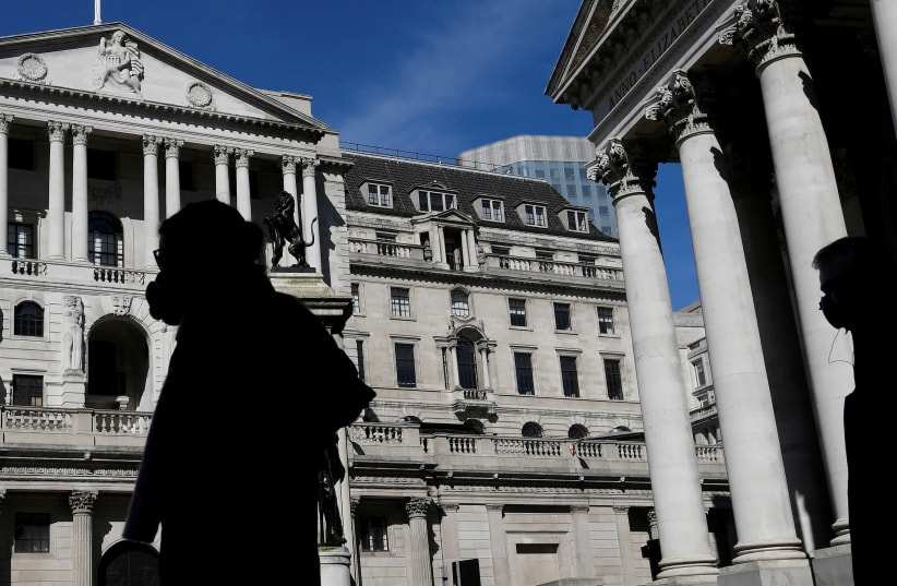 People wearing masks walk past the Bank of England (photo credit: REUTERS)