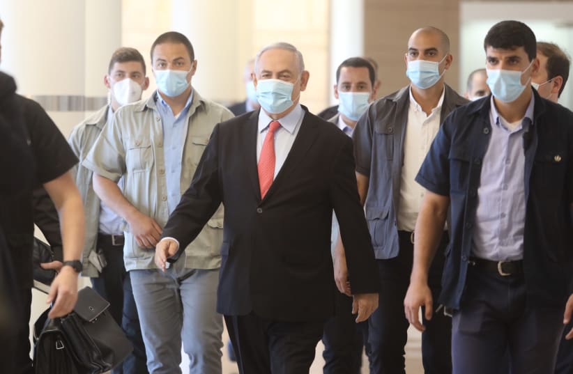 Prime Minister Benjamin Netanyahu walking through the Knesset, wearing a mask amid the coronavirus pandemic (photo credit: MARC ISRAEL SELLEM/THE JERUSALEM POST)