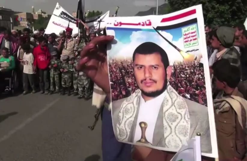 A Houthi holds up an image of Abdul-Malik Badreddin al-Houthi, the movement leader, during protests against the Saudi Arabian-led coalition (photo credit: WIKIPEDIA)