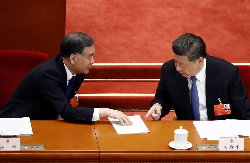 Chinese President Xi Jinping and Wang Yang, chairman of the National Committee of the Chinese People's Political Consultative Conference (CPPCC), talk at the second plenary session of the National People's Congress (NPC) at the Great Hall of the People in Beijing, China May 25, 2020 (photo credit: REUTERS)