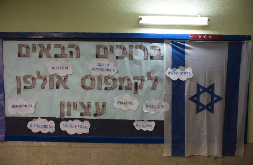 A welcome sign and an Israeli flag hang at Ulpan Etzion, the original residential school and absorption centre, which has taught Hebrew to tens of thousands of immigrants since 1949, in Jerusalem January 20, 2015 (photo credit: REUTERS/Ronen Zvulun)