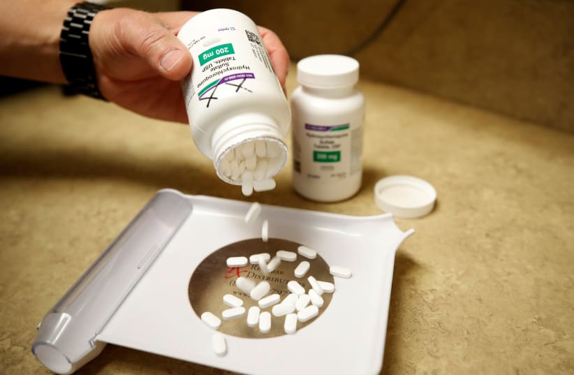The drug hydroxychloroquine, pushed by U.S. President Donald Trump and others in recent months as a possible treatment to people infected with the coronavirus disease (COVID-19), is displayed by a pharmacist at the Rock Canyon Pharmacy in Provo, Utah, U.S., May 27, 2020 (photo credit: REUTERS/GEORGE FREY)
