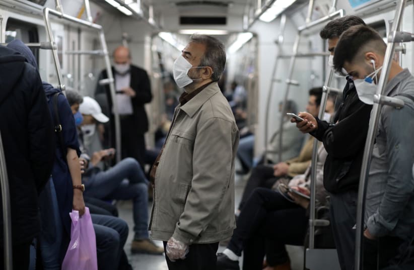 Iranians wear protective face masks, following the outbreak of the coronavirus disease (COVID-19), as they drive with the metro, in Tehran, Iran, May 20, 2020 (photo credit: REUTERS)
