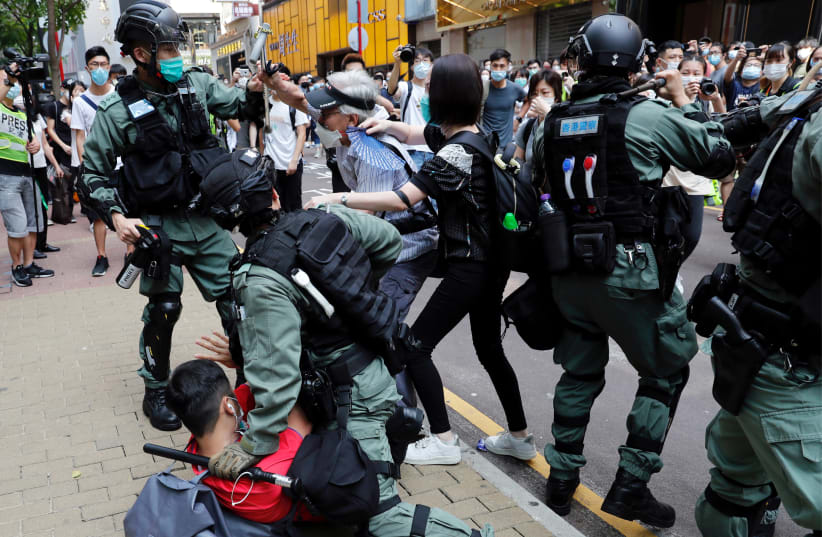 Anti-government demonstrators scuffle with riot police during a lunch time protest as a second reading of a controversial national anthem law takes place in Hong Kong, China May 27, 2020. (photo credit: TYRONE SIU/ REUTERS)