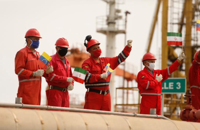 Workers of the state-oil company Pdvsa holding Iranian and Venezuelan flags greet during the arrival of the Iranian tanker ship "Fortune" at El Palito refinery in Puerto Cabello, Venezuela May 25, 2020 (photo credit: MIRAFLORES PALACE/HANDOUT VIA REUTERS)