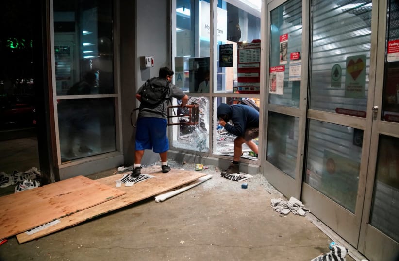 People loot property during nationwide unrest following the death in Minneapolis police custody of George Floyd, in Los Angeles, California, U.S., May 30, 2020. Picture taken May 30, 2020.  (photo credit: REUTERS)