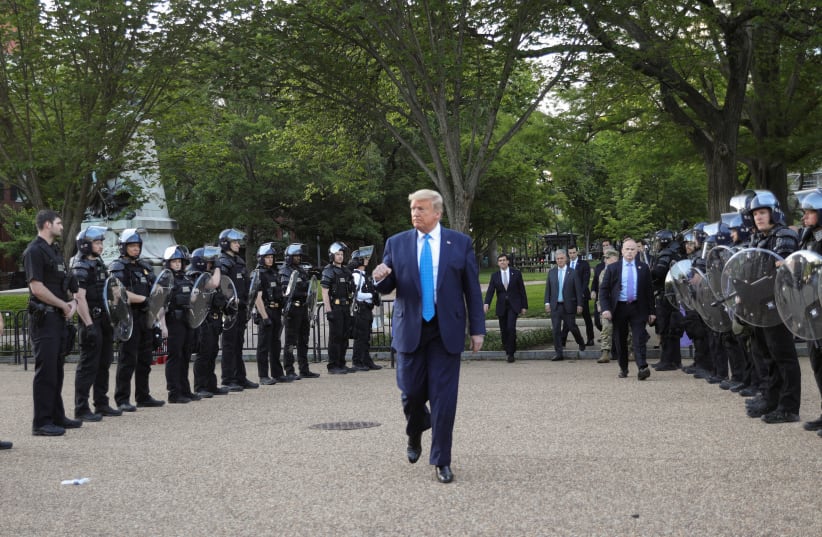 US President Trump walks between lines of riot police in Washington, June 1, 2020 (photo credit: TOM BRENNER/REUTERS)