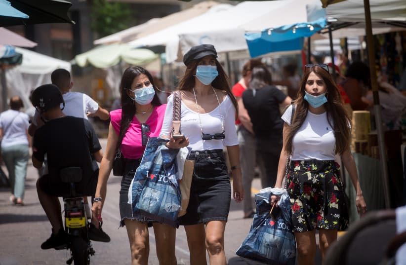 People wear masks as they walk through the  Nahalat Binyamin art market which was reopened, following a closure of several weeks due to the Coronavirus.  June 2, 2020 (photo credit: MIRIAM ALSTER/FLASH90)