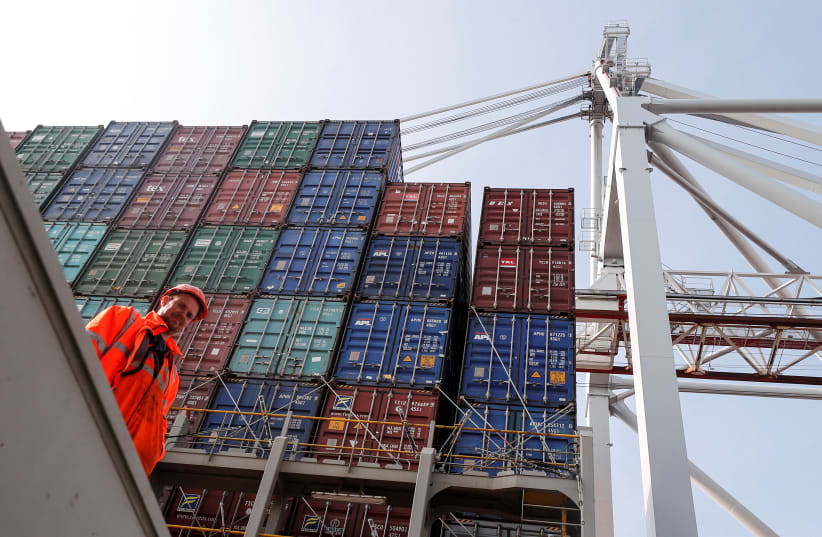 Freight containers are seen on a freight container ship as a worker looks on at DP World, Southampton Docks, in Southampton, Britain, March 27, 2017. (photo credit: REUTERS/EDDIE KEOGH)