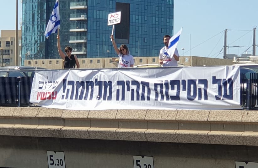 Peace Now members with a large banner saying "Over the Annexation - There Will Be War"  (photo credit: Courtesy)