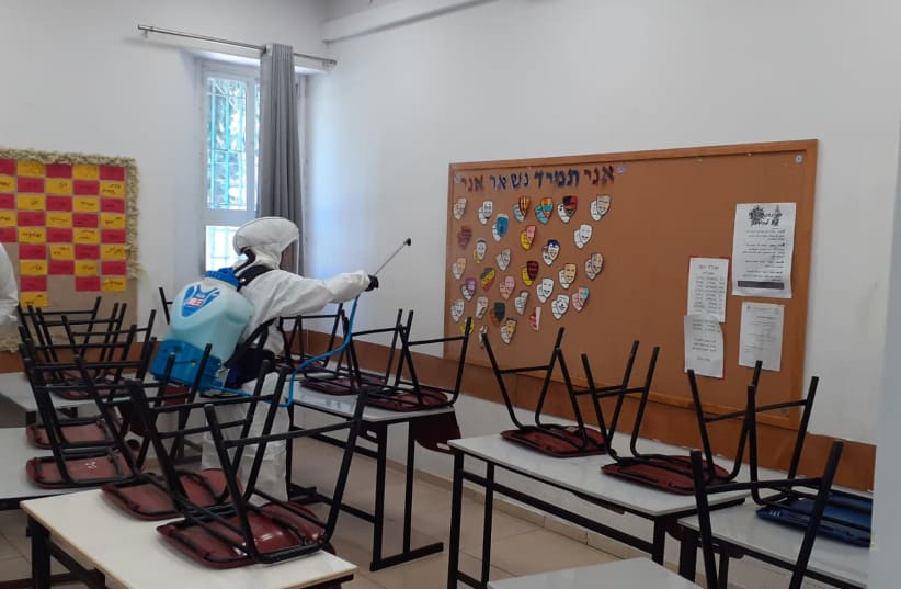 A worker from the Jerusalem municipality disinfects a city school. June 3, 2020.  (photo credit: COURTESY JERUSALEM MUNICIPALITY)
