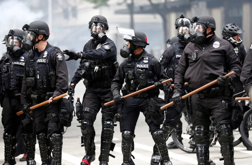 FILE PHOTO: Seattle police form a line after deploying pepper spray and flash-bang devices during a protest against the death in Minneapolis police custody of George Floyd, in Seattle, Washington, U.S. May 31, 2020.  (photo credit: REUTERS/LINDSEY WASSON)