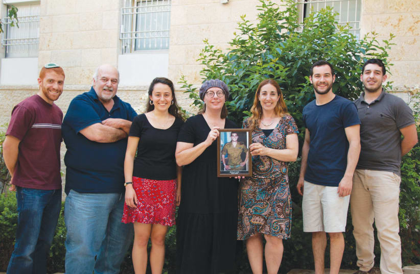 THE BASE staff ‘take dedication to a new level’: Co-directors Bonnie Rosenbaum (fourth from left) and Lizzie Noach (third from right) proudly display a picture of Michael Levin (photo credit: EZRA WEISER)