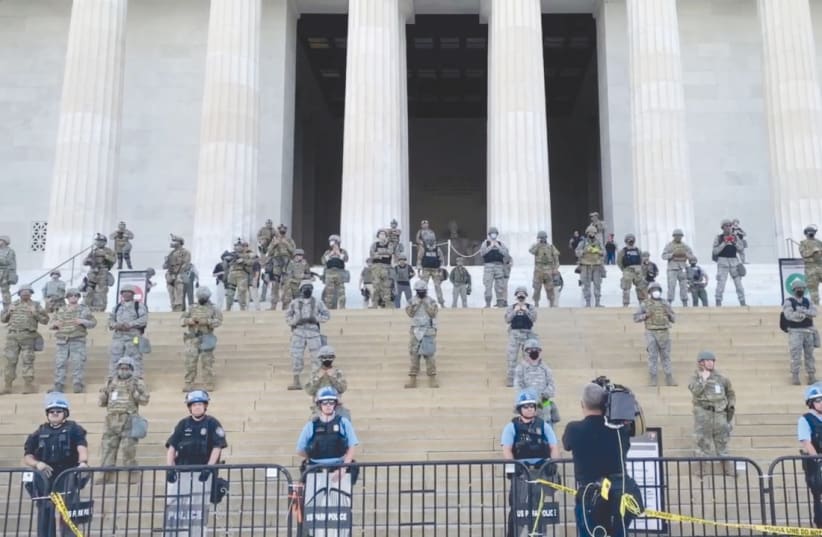 LAW ENFORCEMENT personnel stand guard on the steps of the Lincoln Memorial (photo credit: JAMES HARNETT/SOCIAL MEDIA VIA REUTERS)