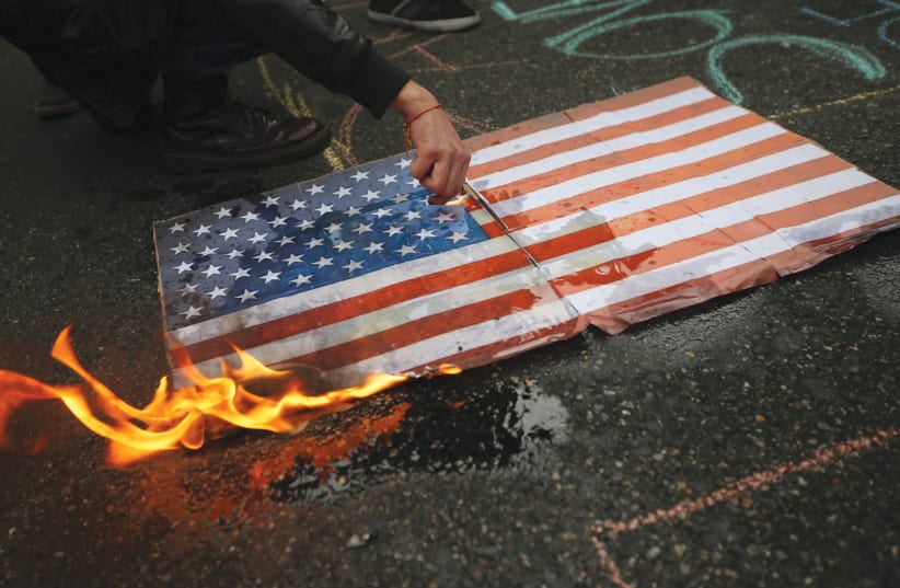 Protestors burn a US flag (photo credit: REUTERS)