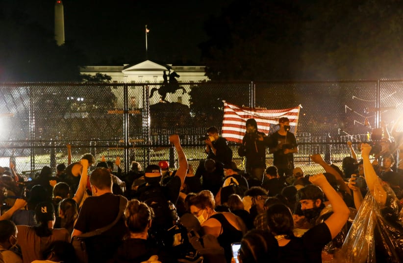Demonstrators gather behind a fence during a protest against the death in Minneapolis police custody of George Floyd, in Lafayette Park in front of the White House, in Washington, U.S., June 4, 2020 (photo credit: REUTERS/JIM BOURG)