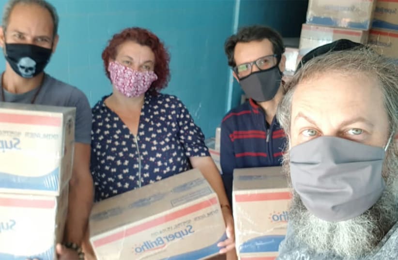 Rabbi Gilberto Ventura, right, and volunteers prepare to dispatch food packages to a needy residents of Sao Paulo, Brazil, May 27, 2020 (photo credit: COURTESY OF SINAGOGA SEM FRONTEIRAS/JTA)