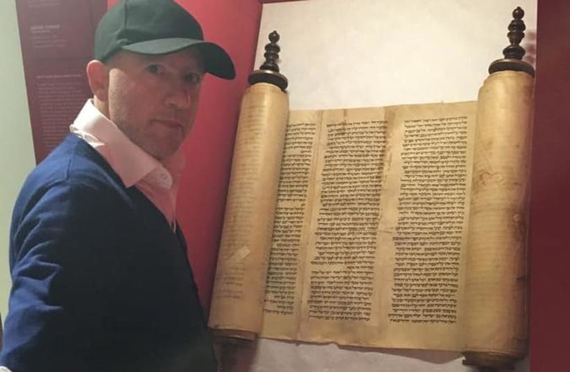 Rabbi Amedeo Spagnoletto with 13th century Torah scroll  (photo credit: MARCO CASELLI / MUSEUM OF ITALIAN JUDAISM AND THE HOLOCAUST)