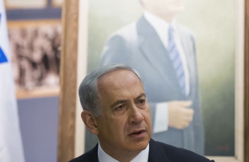 A TALE of two prime ministers. A portrait of Menachem Begin behind Benjamin Netanyahu (photo credit: URIEL SINAI/POOL/REUTERS)