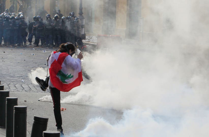 A demonstrator kicks back a tear gas canister during a protest against the government performance and worsening economic conditions, in Beirut, Lebanon June 6, 2020 (photo credit: AZIZ TAHER/REUTERS)