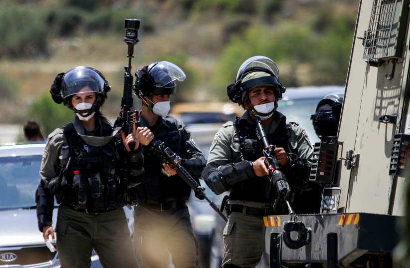 Israeli security forces guard as Palestinians protest against Israel's plan to annex parts of the West Bank, near Tulkarm, in the West Bank on June 5, 2020. (photo credit: NASSER ISHTAYEH/FLASH90)