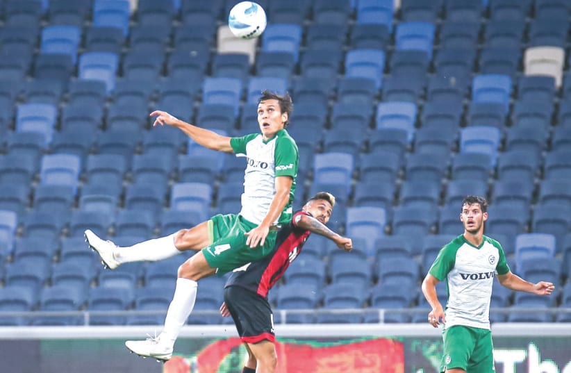 MACCABI HAIFA (in green) and Hapoel Haifa battled to a 2-2 draw on Sunday night at Sammy Ofer Stadium in Israel Premier League Championship Playoff action (photo credit: MAOR ELKASLASI)
