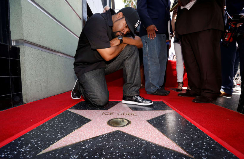Rapper Ice Cube poses by his star after it was unveiled on the Hollywood Walk of Fame in Los Angeles (photo credit: REUTERS)