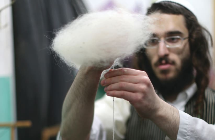 USING WOOL to prepare the thread for the making of tzitzit. (photo credit: NATI SHOHAT/FLASH90)