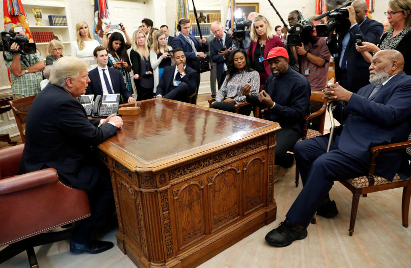 U.S. President Donald Trump listens as rapper Kanye West speaks during a meeting with NFL Hall of Fame player Jim Brown (R) and others in the Oval Office at the White House in Washington, U.S., October 11, 2018 (photo credit: REUTERS)