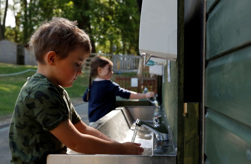 FILE PHOTO: Children are seen washing their hands at Heath Mount School as some schools reopen, following the outbreak of the coronavirus disease (COVID-19), Watton-at-Stone, Britain, June 2, 2020. (photo credit: ANDREW COULDRIDGE/REUTERS)