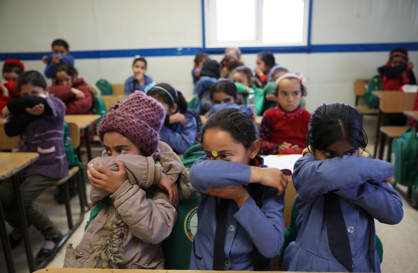 Syrian refugee students take part in a washing hands activity during an awareness campaign about coronavirus initiated by OXFAM and UNICEF at Zaatari refugee camp in the Jordanian city of Mafraq, near the border with Syria, March 11, 2020 (photo credit: REUTERS/MUHAMMAD HAMED)