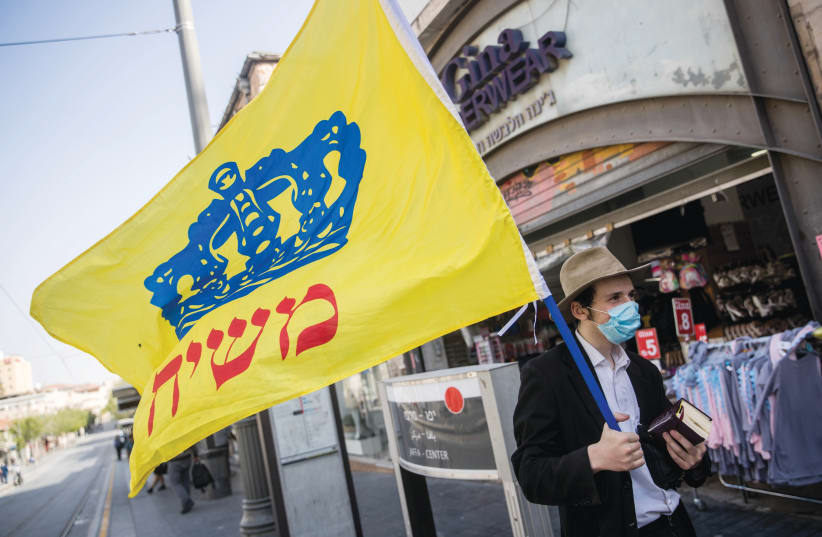 CHABAD’S ‘REDEMPTIVE scenario has a “tremendous energy” which explains “the amount of sacrifice these people are willing to make”’: A man foists the Chabad flag on Jerusalem’s Jaffa Road on April 20. (photo credit: YONATAN SINDEL/FLASH90)