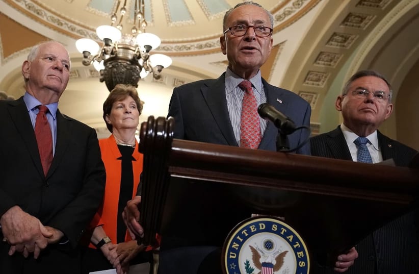 Senate Minority Leader Chuck Schumer, at mic, speaks at a news briefing at the Capitol, July 17, 2018. Left to right in the background are Sens. Ben Cardin, Jeanne Shaheen and Robert Menendez (photo credit: ALEX WONG/GETTY IMAGES/JTA)