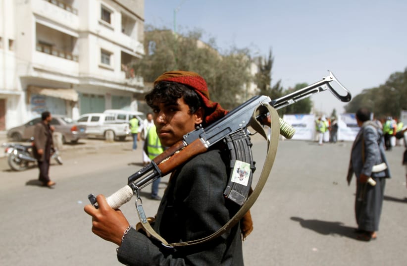A Houthi supporter looks on as he carries a weapon during a gathering in Sanaa, Yemen April 2, 2020 (photo credit: REUTERS/MOHAMED AL-SAYAGHI)