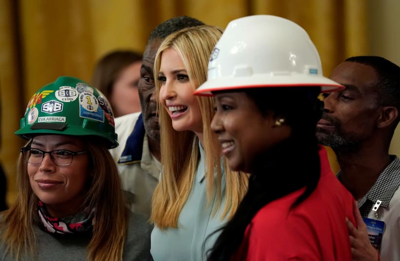 Ivanka Trump poses for a photo with workers during U.S. President Donald Trump's signing event for an Executive Order that establishes a National Council for the American Worker at the White House in Washington, US, July 19, 2018. (photo credit: KEVIN LAMARQUE/REUTERS)