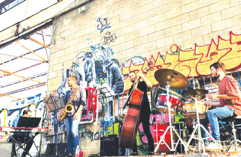 JAZZ MUSICIANS perform in a Tel Aviv parking lot during the coronavirus pandemic. (photo credit: SHAI NITZAN)