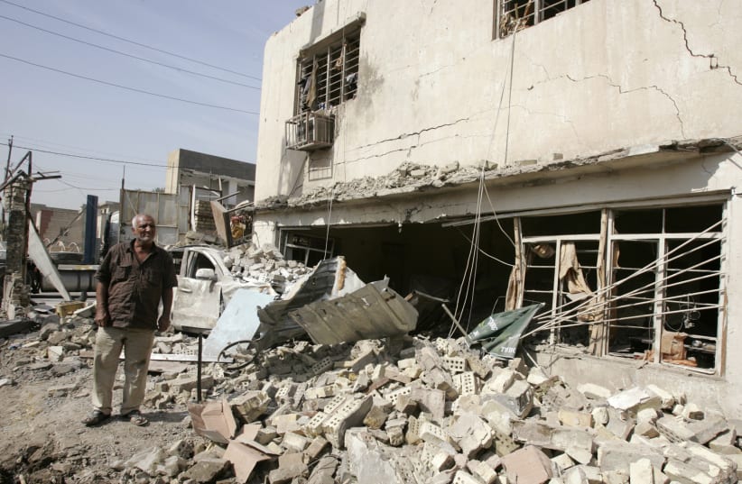 A resident inspects the site of a blast, a day after a bomb attack targeted a liquor store, in Baghdad October 18, 2011. A parked car bomb went off in Karrada, a central district of Baghdad, killing eight people including three policemen and wounded 18 others late on Monday, police and hospital sour (photo credit: REUTERS/MAHMOUD RAOUF)