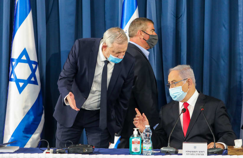 Defense Minister Benny Gantz talks to Prime Minister Benjamin Netanyahu as Foreign Minister Gabi Ashkenazi walks by at a cabinet meeting on June 7 (photo credit: MARC ISRAEL SELLEM)