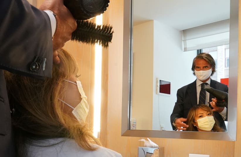 Julien Farel cuts a woman's hair in his salon. New York City, June 22, 2020. (photo credit: REUTERS/CARLO ALLEGRI)