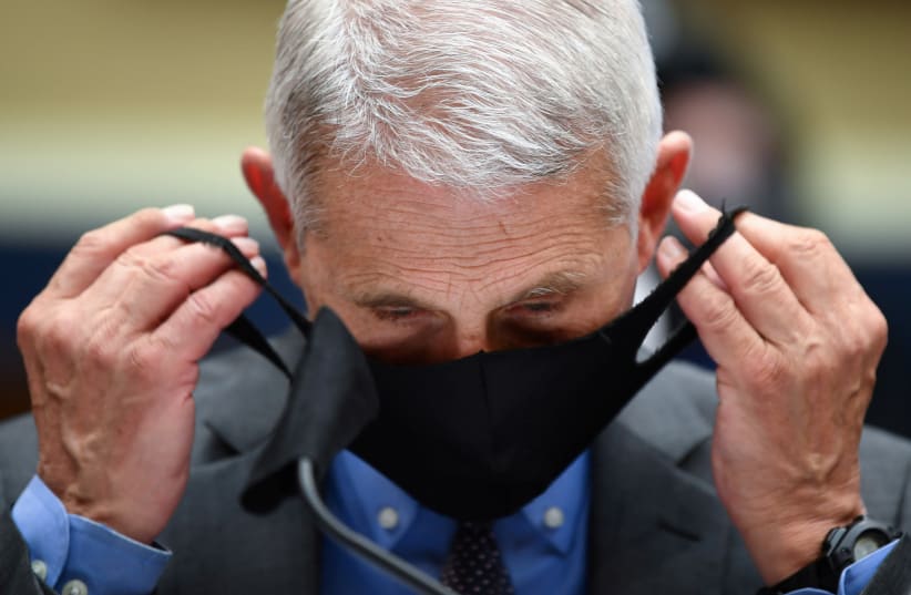 Director of the National Institute for Allergy and Infectious Diseases Dr. Anthony Fauci takes off his face mask prior testifying before the House Committee on Energy and Commerce on the Trump Administration's Response to the COVID-19 Pandemic, on Capitol Hill in Washington, DC, U.S. June 23, 2020 (photo credit: REUTERS)