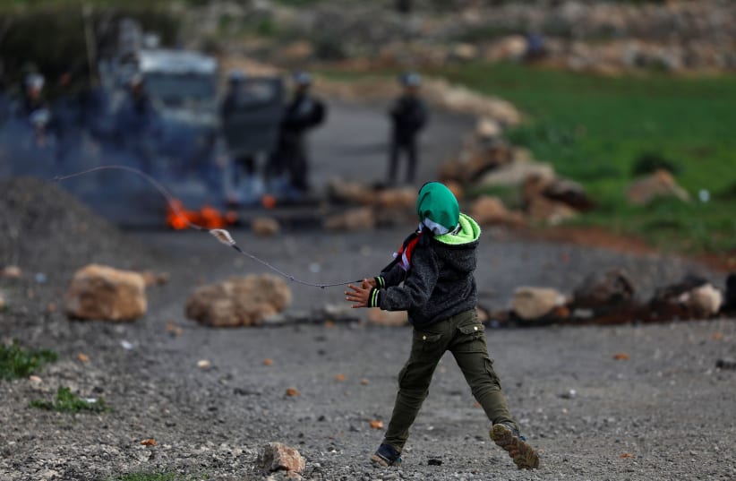 Palestinian boy hurls stones at Israeli troops during clashes in the West Bank (photo credit: REUTERS)