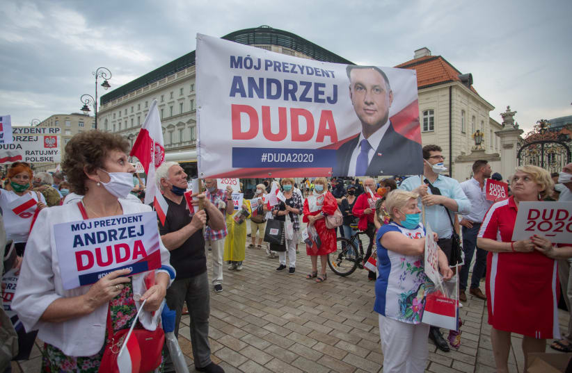 Supporters of Poland's President Andrzej Duda hold placards during a presidential election campaign event in Warsaw, Poland, June 26, 2020 (photo credit: AGENCJA GAZETA/ADAM STEPIEN VIA REUTERS)